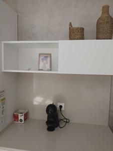 a white shelf with a picture and a stuffed animal at Apartment Moni 3 in Veliko Tŭrnovo