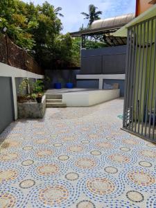 a patio with a mosaic tile floor on a building at Candava's Residence in Puerto Galera