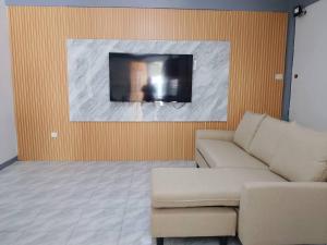 a living room with a couch and a tv on a wall at Candava's Residence in Puerto Galera +5 photos