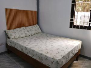 a small bed in a room with a bedspread on it at Candava's Residence in Puerto Galera