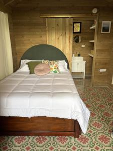 a bedroom with a large bed with a wooden wall at Ecolodge Finca Lalu in Santa Rosa de Cabal +15 photos