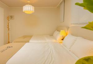 a bedroom with two beds and a chandelier at The Stay Gangnam COEX Hanti Station 5 minutes! 3Queen Bed in Seoul