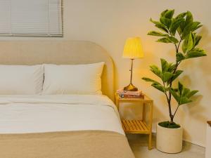 a bedroom with a bed and a plant next to a lamp at The Stay Gangnam COEX Hanti Station 5 minutes! 3Queen Bed in Seoul