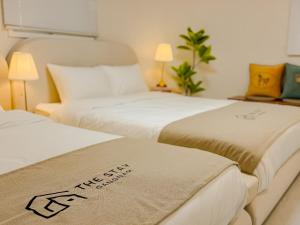 two beds in a hotel room with white sheets at The Stay Gangnam COEX Hanti Station 5 minutes! 3Queen Bed in Seoul