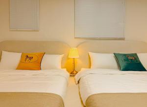two beds sitting next to each other in a bedroom at The Stay Gangnam COEX Hanti Station 5 minutes! 3Queen Bed in Seoul +51 photos