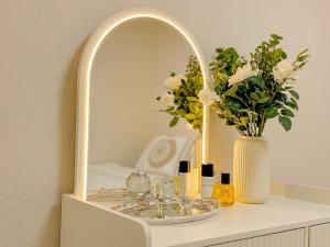 a dressing table with a mirror and a vase with flowers at The Stay Gangnam COEX Hanti Station 5 minutes! 3Queen Bed in Seoul