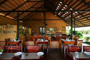 a restaurant with tables and chairs and a dining area at Aalterra Resort by The Almanac in Wayanad