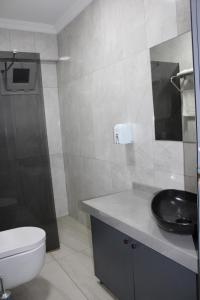 a bathroom with a black sink and a toilet at Deniz Hotel Kumburgaz in Büyükçekmece