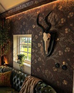 a living room with a wall with a deer skull on it at Grynnan in Skå