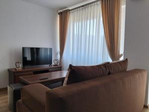 a living room with a couch and a flat screen tv at GH Apartments 2 in Gura Humorului