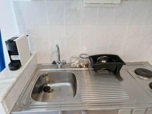 a kitchen sink with a tray on the side of it at Thalias apartments in Kómi