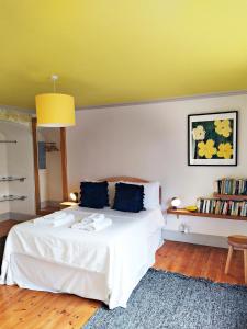 a bedroom with a white bed with a yellow ceiling at Quay Street in Lostwithiel