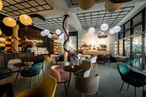 a restaurant with tables and chairs and chandeliers at Kabesera Bed and Coffee in Binangonan