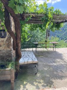 a bench sitting under a pergola next to a tree at Le Mafaté - Vallée de l'Eyrieux in Saint Maurice en Chalencon