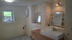a bathroom with a sink and a mirror at Ferienhaus am Ring in Wimbach +14 photos