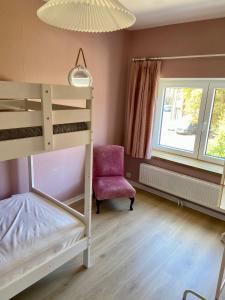 a bedroom with a bunk bed and a chair at A l'ombre du cèdre in Grez-Doiceau