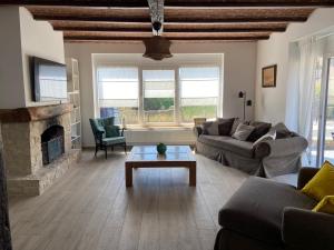 a living room with a couch and a fireplace at A l'ombre du cèdre in Grez-Doiceau