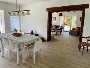 a dining room with a white table and chairs at A l'ombre du cèdre in Grez-Doiceau