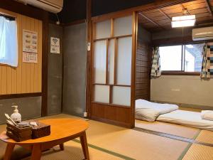 a room with two beds and a table in it at wagaranchi in Kumano