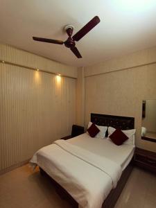 a bedroom with a bed with a ceiling fan at Sai holidays in Ayodhya