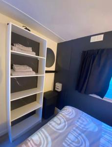 a bedroom with a bed and a white closet at Mobil-home dans un camping calme et familial chez César in Cambo-les-Bains +5 photos