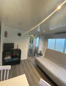 a bedroom with a large bed and a table at Mobil-home dans un camping calme et familial chez César in Cambo-les-Bains