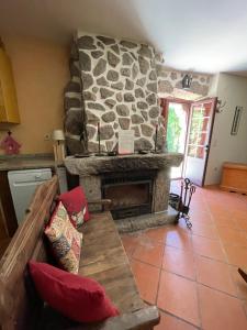 a living room with a stone fireplace and a couch at Casa do Palheiro de Cima in Geres