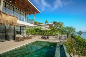 an exterior view of a house with a swimming pool at Fishman Beachfront Villas in Haad Pleayleam