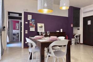 a dining room with a wooden table and white chairs at Casa di Silvia city center in Verona