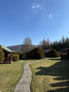 a stone path leading to a yard with houses at Trzy Domki Wysowa in Wysowa-Zdrój