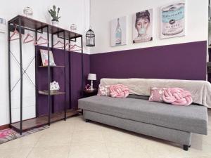 a living room with a couch with pink pillows on it at Casa di Silvia city center in Verona