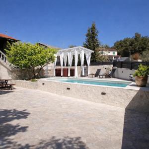 a swimming pool with a pavilion next to a house at Villa Roko - Luxury Villa 60m from beach! in Ždrelac