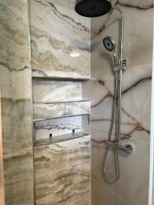 a shower with a shower head in a bathroom at Apartament Modern Herne 3 in Herne