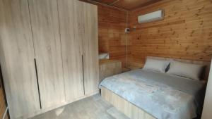 a small bedroom with a bed in a wooden cabin at Vruçaj' s Cabin in Bogë