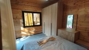 a bedroom with a bed in a wooden cabin at Vruçaj' s Cabin in Bogë +4 photos