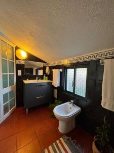 a bathroom with a white toilet and a sink at Lucky Jack in Jardim do Mar