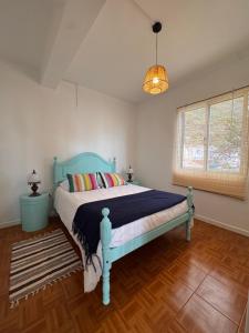 a bedroom with a blue bed and a window at Lucky Jack in Jardim do Mar