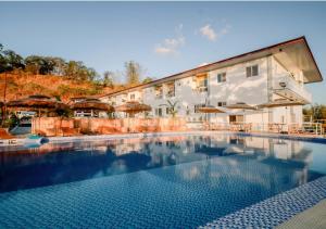 a large swimming pool in front of a hotel at Kabesera Bed and Coffee in Binangonan