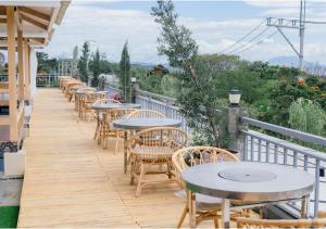 a row of tables and chairs on a balcony at Kabesera Bed and Coffee in Binangonan