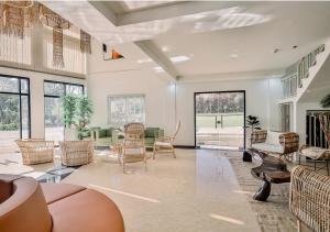 a large living room with chairs and tables at Kabesera Bed and Coffee in Binangonan