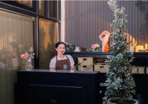 a woman sitting at a counter in a flower shop at Kabesera Bed and Coffee in Binangonan +53 photos