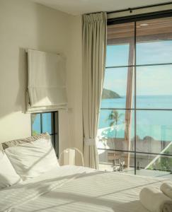 a bedroom with a bed and a large window at Fishman Beachfront Villas in Haad Pleayleam +56 photos