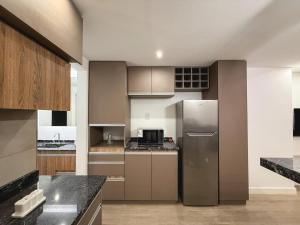 a kitchen with a stainless steel refrigerator and cabinets at Aura Urbana Apartment in San Juan