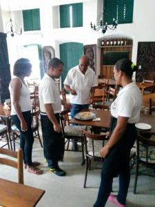 een groep mensen die rond een tafel staan bij Pousada Pai Thomaz in Cachoeira