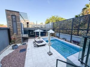 a swimming pool with two umbrellas on a building at Aura Urbana Apartment in San Juan