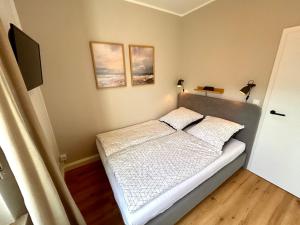 a bedroom with a bed and two pictures on the wall at SielundMeer in Neuharlingersiel
