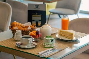 a table with a breakfast of bread and coffee and a basket of fruit at Hotel Convencion in Trujillo +11 photos