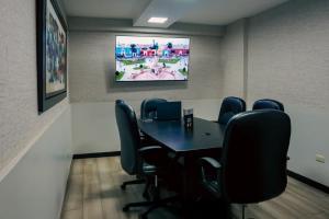 a conference room with a table and chairs and a tv at Hotel Convencion in Trujillo