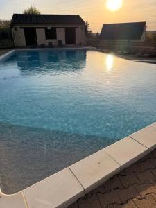 a swimming pool with blue water in front of a house at Gîte de la Bastide de Domme in Domme