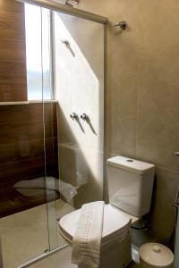 a bathroom with a toilet and a glass shower at Premium Executive Hotel Itabira in Itabira +65 photos